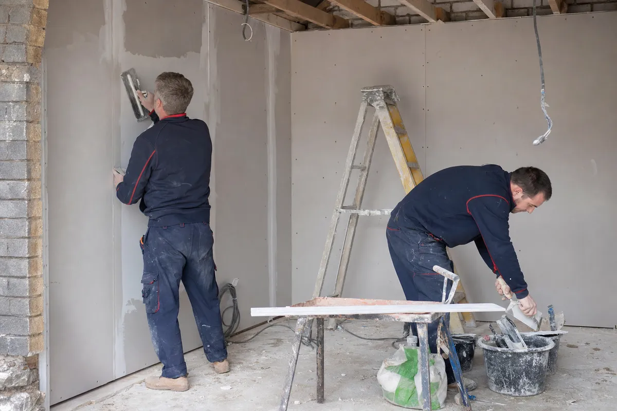 Builder in navy Carter LS workwear blocking up a garage door opening on a Wolverhampton house