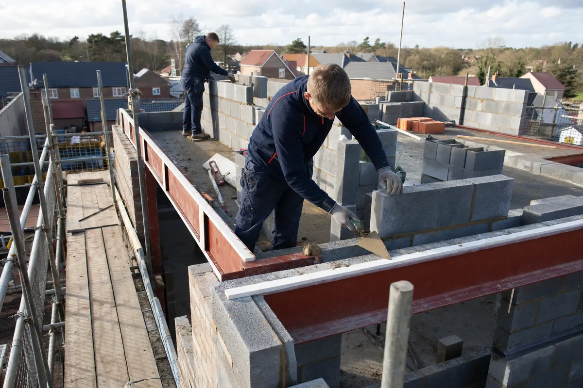 Carter LS builders in navy workwear setting out blockwork on a new build plot in South Staffordshire